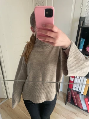 Stickad polotröja  - Stickad polotröja med vida ärmar och slit i sidorna, brun färg i stolek s från Gina Tricot 