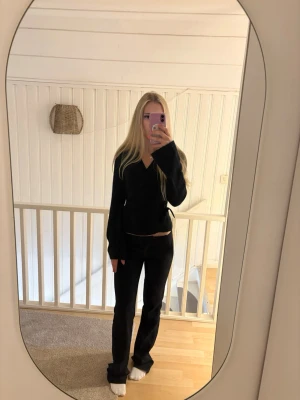 Svart stickad omlottkofta - Säljer ett par svarta byxor med rak passform och normal midja. Byxorna är tillverkade i mjuk bomull och har en stilren look som funkar till det mesta. Perfekta för dig som gillar klassiska och enkla byxor.