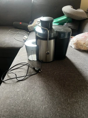 Rostfri juicepress med tillbehör - Juicepress i rostfritt stål och svart plast med flera löstagbara delar. Perfekt för att snabbt göra färsk juice hemma. Medföljande kanna och pressverktyg ingår. Enkel att montera isär och rengöra. Snygg och modern design som passar i de flesta kök.