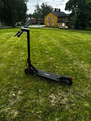 IScooter i9-Max - Elektrisk scooter i svart med röda detaljer och robust ram. Scootern har stora hjul, handtag med greppvänligt material och en tydlig display på styret. Märkt med ”IScooter' på fotplattan. Perfekt för smidig transport i stan. 500 W, toppfart 35km/h,  batteri 36V 10Ah med räckvidd 30-35km. Priset kan sänkas. Väger 22kg.