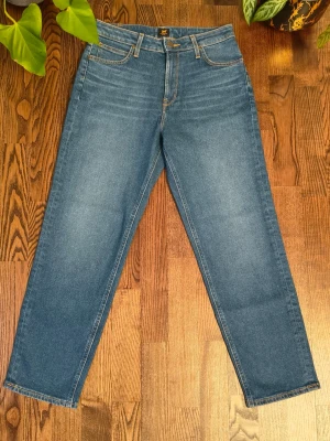 Blå raka jeans från Lee - Klassiska blå jeans från Lee med rak passform och fyra fickor. Jeansen har normal midja, gylf med dragkedja och knapp samt kontrastsömmar. Tillverkade i slitstark denim som passar perfekt till en avslappnad stil.