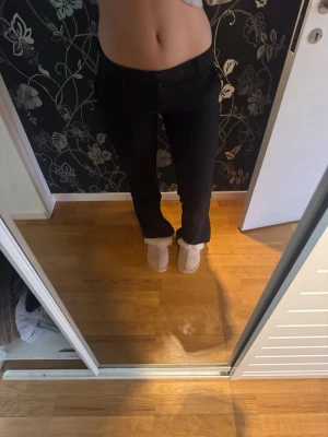 Svarta kostymbyxor från bikbok - Säljer ett par svarta kostymbyxor med rak passform och ganska låg midha. Byxorna har klassisk design med knapp och dragkedja framtill samt diskreta fickor i sidorna. Perfekta för en clean och stilren look. 