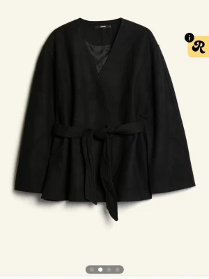 Svart kappa med knytskärp - Svart "Zina Kappa" från bikbok köpt för 699kr. Kappan har v-ringad hals och har ett knytband som gör hela outfiten. Kan gå ner i pris. 