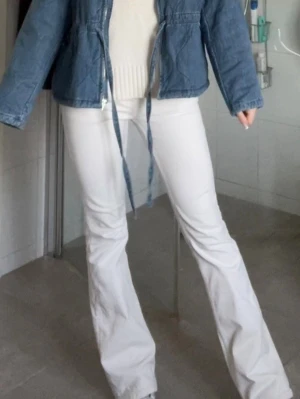 Vita bootcut jeans - Säljer ett par vita bootcut jeans med låg midja och klassiska fem fickor. Jeansen har en snygg utsvängd passform och är tillverkade i ett stretchigt denimtyg som sitter bekvämt. Perfekta för dig som vill ha en clean och trendig look 💞💞
