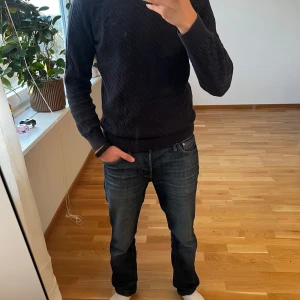 Mörkblå stickad tröja från GANT - Säljer en stilren mörkblå stickad tröja från GANT. Tröjan har ett diskret mönster och rund halsringning. Perfekt för kyligare dagar och passar bra till både jeans och chinos. Ett måste i garderoben för den som gillar klassisk stil. Pris går att diskutera