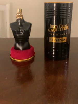 Jean Paul Gaultier Le Male Le Parfum 125ml - Snygg parfymflaska från Jean Paul Gaultier, Le Male Le Parfum. Flaskan är formad som en svart manlig torso med gulddetaljer och kommer med en svart och guldig cylinderformad förpackning. Perfekt för dig som gillar exklusiva och unika dofter.