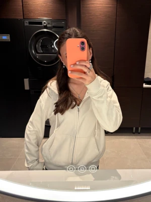 Vit zip hoodie med fickor - Säljer en vit hoodie med dragkedja och två stora fickor framtill. Hoodien har en klassisk passform och är gjord i mjukt material som känns skönt mot huden. Perfekt för att slänga på sig när man vill vara bekväm och ändå se snygg ut.🍵🎧💖