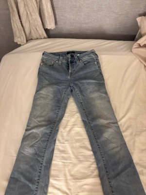 Ljusblå raka jeans från true religion - Säljer ett par ljusblå jeans från true religion med rak passform men är även lite utsvängda längst ner. Säljer dom för jag knappt har använt dom och kommer inte till användning. Nypris 1200 ungefär, priset kan diskuteras.