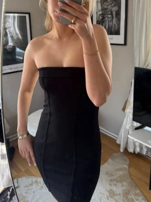 Svart bandeau klänning  - Snygg svart bandeau klänning med figurnära passform. Klänningen är kort och har en stilren, minimalistisk design. 