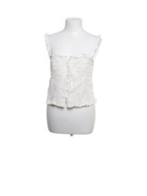 Vit spetsig linnetopp med volang - Söt vit linnetopp med spetsdetaljer och volangkant. Toppen har smala axelband och knappar framtill. Perfekt för sommarens alla tillfällen och ger en romantisk vibe till din outfit.