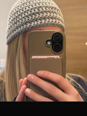 Virkad mössa i ljusblått/grått och vitt - Säljer en handvirkad mössa i mjukt garn med breda ränder i ljusgrått och vitt. Mössan har en klassisk rundad form och är perfekt för dig som gillar en chill och stilren look. Passar både till streetwear och casual outfits.