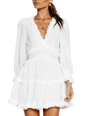 Studentklänning vit  - Superfin vit kort omlottklänning med volangdetaljer och v-ringning. Klänningen har långa ärmar och öppen rygg, vilket ger en snygg och trendig look. Perfekt för exempelvis studenten. Denna klänning är ej använd