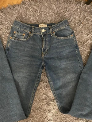Gina jeans - Lowwaist bootcut modellen från Gina Tricot, blå jeans från med fem fickor. Jeansen har en snygg tvätt och knapp- och dragkedjestängning. Perfekta för en avslappnad och stilren look. Knappt andvända 😊