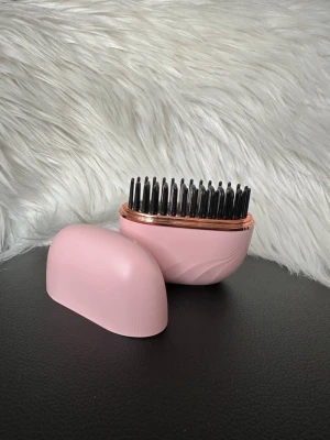 Mini kamm plattång  - Mini plattång med tre värmefunktioner och laddningsbar. Perfekt att ha i väskan tack vare det medföljande locket som skyddar borsten. Oval form och modern design.