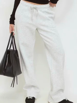 Gråa vida mjukisbyxor med dragsko - Snygga ljusgrå mjukisbyxor med rak och lös passform. Byxorna har resår och dragsko i midjan för extra komfort. Perfekta för en avslappnad stil och tillverkade i mjukt material.