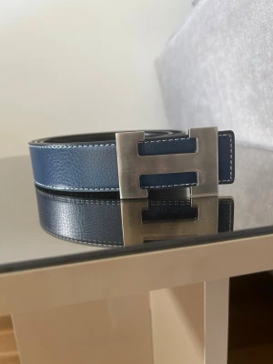 H bälte - Marinblå skärp  med ett stilren silver H i mitten som är stilig för dig och är helt oanvänd