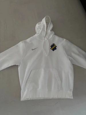 AIK hoodie  - Vit AIK hoodie med sköld och snyggt grått Nike emblem. Storlek L. Passformen är lite oversized i armarna och funkar också som en stor M. Använd några få gånger. Köpt från AIK shopen 2024. 