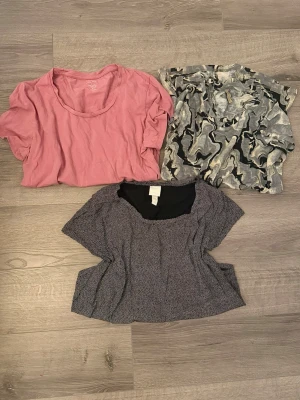 Klädpaket i varierande storlekar  - Säljer ett fint paket med tre olika toppar i bra skick.  Pris är inte förhandlingsbart då det redan är stor rabatt. Använd bundle för ännu mer rabatt!  - Rosa T-shirt från Twilfit: En mjuk och bekväm klassiker i en dov rosa ton. Storlek L. - Prickig topp från H&M Basic: Tidlös svartvit modell i 100% bomull. Storlek S. - Mönstrad topp från Soyaconcept: Trendigt abstrakt mönster i grått/svart. 100% polyester. Storlek XS.