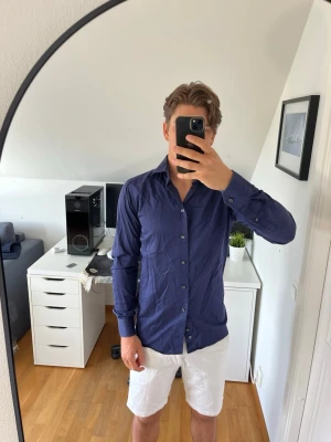 Mörkblå skjorta från Eton - Snygg mörkblå skjorta från Eton med klassisk krage och knappar framtill. Skjortan har lång ärm och är tillverkad i ett tunt och skönt bomullstyg. Hör gärna av dig vid frågor!