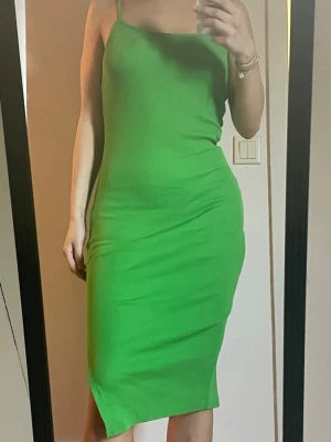 Grön tight klänning med slits - Somrig grön klänning från New Yorker som ger fin form på kroppen och har mjukt skönt material! Stl: M