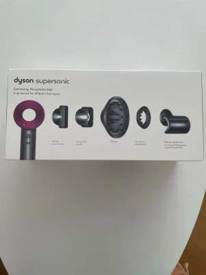 Dyson Supersonic hårfön - Dyson Supersonic hårfön med flera tillbehör som stylingkoncentrator, slät munstycke, diffuser, gentle air och flyaway-verktyg. Fönen är grå med lila detaljer och tillverkad i plast och metall. Perfekt för olika hårtyper och snabb torkning.