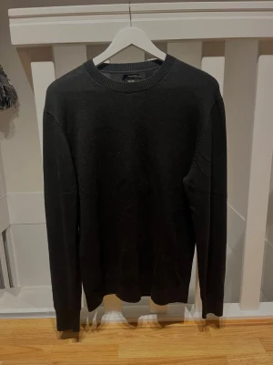 Svart stickad tröja Massimo Dutti - Klassisk svart stickad tröja från Massimo Dutti med rund halsringning och ribbade muddar. Enkel och stilren design som passar till det mesta. Tillverkad i mjukt merino/bommul blandning för en bekväm och uppklädd känsla. Vid minsta fråga hör av dig, mvh✌️