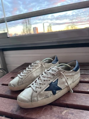 Golden Goose skor - Säljer dessa snygga sneakers ifrån Golden Goose. Skorna är i tillfredställande skick, där de används under ca ett års tid. Som man ser på bilderna finns det defekter. De visas på bilderna, där sulan är lite sönder. Men det är inget lite skolim säkert kan lösa:) Några av fläckarna är också en del av designen.  Köpte dessa förra året för 4599kr, och därav priset. De är fortfarande ett par riktigt snygga och trendiga skor. Hör av dig vid funderingar!
