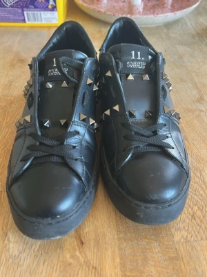Svarta valentino sneakers med nitar  - Coola svarta sneakers från valentino med silverfärgade pyramidnitar på sidorna och runt hälen. Skorna har används max 10 gånger av den jag köpte de av innan. Säljer då de var för små för mig!