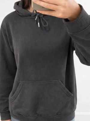 Mörkgrå hoodie med magficka - Säljer en enkel och stilren mörkgrå hoodie med huva och dragsko. Hoodien har en stor magficka framtill och ribbade muddar vid ärmslut och nederkant. Perfekt för en avslappnad look och passar till det mesta. Materialet känns mjukt och bekvämt.