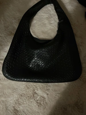 Svart flätad axelväska i skinnimitation - så snygg ”flätad” svart väska - rymlig och bekväm ! passar till jättemycket och är en perfekt väska on the go! skriv vid fler frågor ❤️❤️