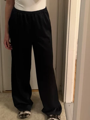 Svarta vida silkesbyxor  - Säljer ett par svarta silkesbyxor från NAKD i storlek 36(är mer som en strl 38 och uppåt) innerbenslängd är 80cm och hela 107cm