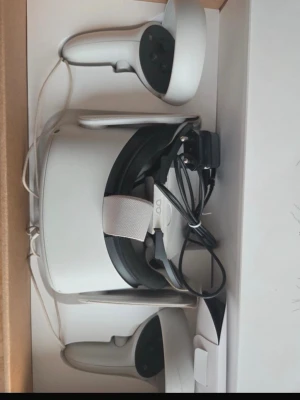 Meta Quest 2 VR-headset med kontroller - Meta Quest 2 VR-headset i vit plast med justerbart band och två matchande handkontroller. Allt levereras i originalkartong. Perfekt för dig som vill uppleva VR-spel och appar på en ny nivå.