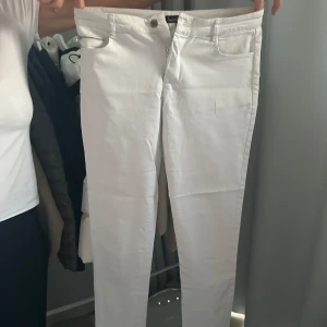 Vita byxor från Smashed Lemon - Snygga vita byxor från Smashed Lemon i storlek M. De har en klassisk design med dragkedja och knapp framtill. Perfekta för en stilren look. Nypris är 1300kr. det är mycket bra kvalitet