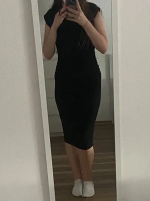 Svart tight klänning med kort ärm - Säljer en svart, figurnära klänning.