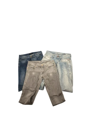 Tre par Replay - Säljer tre par jeans från Replay i olika färger: ett par grå, ett par mörkblå och ett par ljusblå. Alla har klassisk femficksdesign, dragkedjegylf och snygga detaljer vid fickorna. Perfekta för dig som gillar stilrena och trendiga jeans.