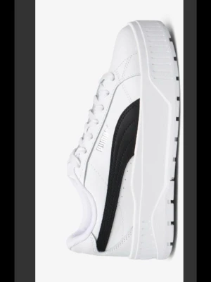 Vita chunky sneakers från Puma - Säljer ett par vita sneakers från Puma med svart sidodetalj och chunky platåsula. Skorna har klassisk snörning, låg profil och är tillverkade i syntetmaterial och läder. Perfekta för dig som gillar streetstyle och vill ha en modern look. Storlek 37 använda en gång av mig! Jätte sköna 