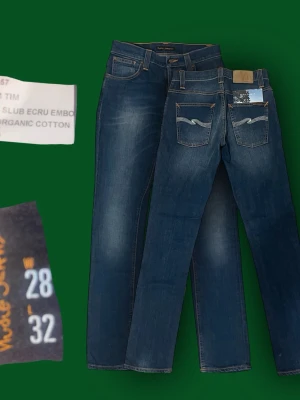 Nudie Grim Tim - Snygga mörkblå jeans från Nudie Jeans med klassisk femficksdesign och kontrastsömmar. Jeansen har raka ben. Materialet är mjukt och stretchigt denim som sitter skönt hela dagen.