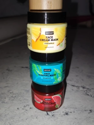 Ansiktsmasker från Sence, 3-pack - Tre olika ansiktsmasker från Sence: en gul Face Cream Mask med ananas, en blå Face Sleeping Mask med sjögräs och en röd Face Gel Peel Off Mask med vattenmelon. Kommer i små burkar av plast med färgglada etiketter. Ej använda men öppnade. 