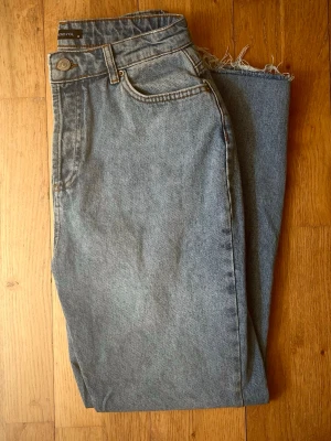 Straight jeans high waisted  - Jeans från Trendyol (köpt från Zalando). Högmidjade jeans med fem fickor och hällor för bälte. Modellen har raka ben med fransiga detaljer. Gylf med fem knappar i metall framtill. Innerbenslängd: 69 cm.