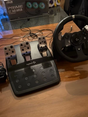 Logitech G920 Driving Force (Xbox/PC) - Säljer ett Logitech G racerratt och pedalset för gaming. Ratten är svart med detaljer i metall och har greppvänligt lädermaterial. Pedalerna är i borstat stål och svart plast, med tre pedaler för gas, broms och växling. Perfekt för racing på PC eller konsol. Pris kan diskuteras
