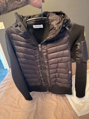 Svart stickad moncler cardigan. - Säljer denna schyssta moncler cardigan åt min lillebror. Sitter väldigt tajt på mig så jag vanligtvis bär S. ⚠️Den är 1 till 1 och oklart om den är akta eller inte. ⚠️ NFC tagg finns 