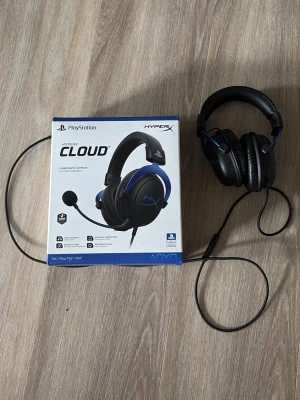 HyperX Cloud headset för PlayStation - HyperX Cloud gamingheadset med svart och blå design, over-ear kåpor och inbyggd mikrofon. Passar till PlayStation och har mjuka öronkuddar för extra komfort. Kabelanslutning för stabil ljudupplevelse. Perfekt för gaming och långa spelsessioner. Tyvärr har jag tappat bort miken till hörlurarna så man kan endast bara höra ifrån dem.