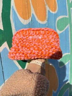 Handvirkad necessär i orange och rosa - Modell AGNES - Rosa/orange - Unik handvirkad necessär från By.Elin i starkt orange och rosa. Mjuk och chunky struktur med rektangulär form, perfekt för småprylar eller smink. Tillverkad i grovt garn som ger en cool och färgstark look.