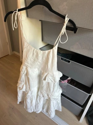 vit volangklänning☀️ - Säljer en supersöt vit klänning från Nelly i storlek XXS 🤍   Endast testad hemma, aldrig använd – alltså i nyskick!    Klänningen har tunna knytbara axelband, feminin passform och fina volangdetaljer som gör den perfekt till studenten, skolavslutning, sommarfester eller semester ✨ Enkel men samtidigt så fin och elegant!    Nypris var 499 kr och modellen är verkligen en perfekt sommarklänning 🌸Pris kan diskuteras!💕