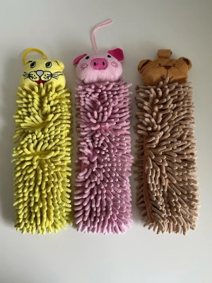 3-pack Norwex djurformade mikrofiberdukar - 3-pack söta barnhanddukar med djurmotiv i mjuk chenille mikrofiber från handduksexperten Norwex. En gul katt/tiger, en rosa gris och en brun björn. Är en del i serien ”Pet to dry” som ska hjälpa mindre barn att lära sig tycka det är roligt att torka händerna genom att klappa på de gulliga djuren. Har ögla för upphängning och mjuka mikrofiberstrån som är sköna att torka händerna på. Snabbtorkande material. 33x12cm. Nypris 290:-/styck, så typ 900:- totalt. Fint skick!