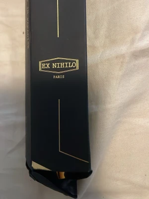 Ex Nihilo Blue Talisman Extrait de Parfum parfymflaska 7,5 ml - Elegant parfymflaska i svart med gulddetaljer, tillverkad i Frankrike. Flaskan rymmer 7,5 ml och har en stilren, avlång form som är enkel att ta med i väskan. Perfekt för dig som gillar lyxiga och klassiska dofter. Marknadspris= 480 Öppen till att förhandla