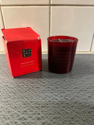 Röd doftljus Balancing från Rituals - Säljer ett rött doftljus Balancing meditation candle från Rituals. Ljuset kommer i ett stilrent rött glas och levereras med originalförpackning. Perfekt för att skapa en lugn och harmonisk atmosfär hemma.