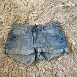 Lågmidjade jeansshorts - Snygga lågmidjade jeansshorts från någon en gammal kollektion från H&M Divided. De köptes second hand men har aldrig använd dem. Väldigt bra skick! MIDJEMÅTT: 34-35cm LÄNGD: 23cm