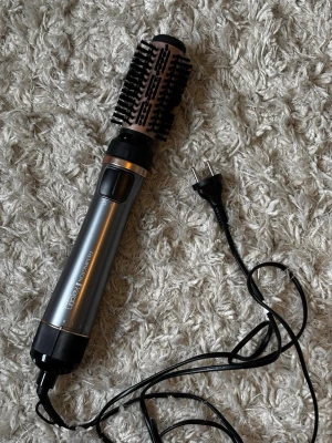 Remington varmluftsborste grå/roséguld - Säljer en Remington varmluftsborste i snygg grå och roséguld design. Borsten har rund form med svarta borststrån och ett handtag i metall och plast. Perfekt för att styla och ge volym till håret. Utrustad med sladd och enkel knapp för inställningar.