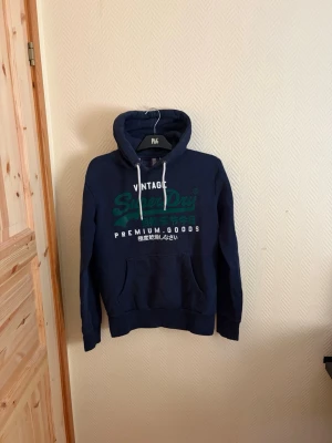 Vintage Superdry Hoodie  - En väldigt snygg Vintage Superdry Hoodie i väldigt bra skick skulle säga 8/10 🤩 Storlek M men passar även Storlek L 🙌                                                               Skriv vid mera frågor/bilder 💬